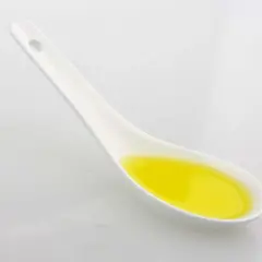 Ein Löffel mit goldenem Olivenöl. Achten Sie auf die Olivenöl Kalorien, wenn Sie es genießen.