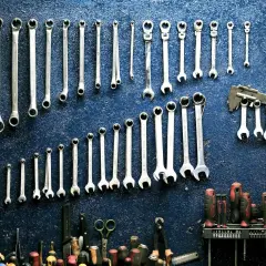 Un mur de garage bleu orné de clés à molette et d'outils divers, rappelant le droit de rétention du garage.