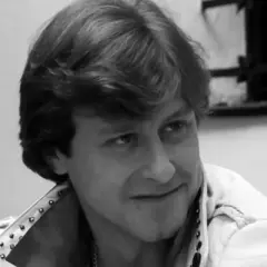 Uśmiechnięty mężczyzna w skórzanej kurtce z ćwiekami, kadr z filmu "Tulipan".