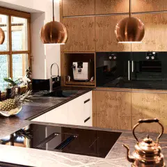 Elegante aplique de cocina con lámparas cobre, encimeras de mármol y electrodomésticos integrados.