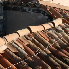 Dettaglio di un vecchio tetto con tegole in terracotta danneggiate, un esempio di come sistemare un vecchio tetto per ripristinarne l'integrità.