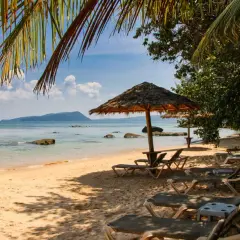 Sonniger Strand in Kambodscha, ein echter Geheimtipp. Liegestühle und Sonnenschirme laden zum Entspannen ein.