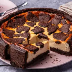 Ein saftiger russischer Zupfkuchen mit dunklem Schokoladenboden und cremiger Käsemasse, belegt mit zupfartigen Schokoladenstücken.