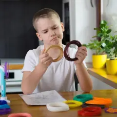 Chłopiec zastanawia się nad kolorami filamentów do drukarki 3D, wspierając swój rozwój sensoryczny.