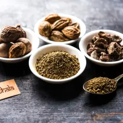 Składniki triphala w miseczkach i na łyżce. Choć znana z dobroczynnych właściwości, warto pamiętać o potencjalnych triphala skutki uboczne.