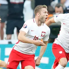 Piłkarze Polski świętują zwycięstwo nad Ukrainą na Euro. Radość na twarzach, biało-czerwone barwy.