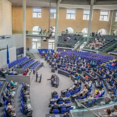 Der Bundestag im Plenum, bereit für einen Hammelsprung. Viele Abgeordnete sitzen auf ihren Plätzen, andere stehen.