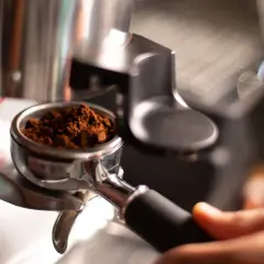 Portafiltro con macinatura caffè fine, pronto per l'estrazione. Regolare la macinatura caffè come fare per un espresso perfetto.