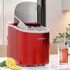 Röd ismaskin, bäst i test, fylld med is och en skopa. Bredvid står ett glas med dryck och citronskivor.