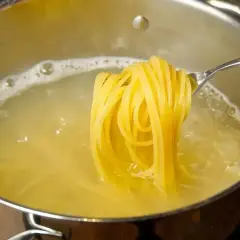 Złociste spaghetti na widelcu, gotujące się w wodzie. Pyszny posiłek, który może być niskokaloryczny, jeśli zwrócimy uwagę na spaghetti kcal.