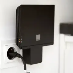 Czarny router Orange, model funbox 6, podłączony do gniazdka elektrycznego.