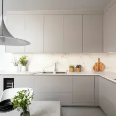 Cuisine moderne avec des meubles hauts gris épurés. La hauteur des meubles hauts cuisine est optimisée pour un rangement maximal.