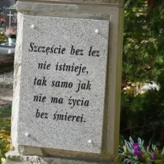 Kamienna płyta na grobie urnowym z napisem "Szczęście bez łez nie istnieje, tak samo jak nie ma życia bez śmierci".