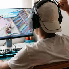 Junge spielt Videospiel, jubelt über Sieg. Er fragt sich, was VSync ist, um Ruckeln zu vermeiden.