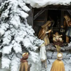 Winterliche Krippenszene mit Maria, Josef und dem Jesuskind. Hirten und Könige nähern sich der Stallung. Ein Sinnbild für Weihnachten und das Christentum.