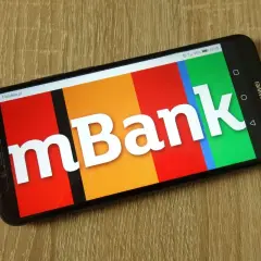 Smartfon z logo mBank na ekranie. Dowiedz się, jak aktywować kartę w aplikacji bankowej.