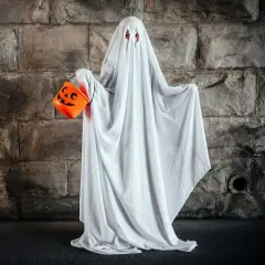 Dziecko w przebraniu na Halloween DIY jako duch, trzymające pomarańczową dynię na cukierki.