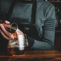 Barman nalewa whisky Glenlivet 12 do szklanki z lodem. Wiele pozytywnych opinii potwierdza jej jakość.