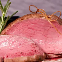 Saftiges Rinderfilet im Backofen, perfekt rosa gebraten, mit Rosmarin und einer dekorativen Schnur aus Bratensaft.
