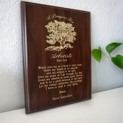 Drewniana tablica z modlitwą dla arborysty, ozdobiona drzewem.