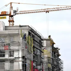 Budowa bloku mieszkalnego z dźwigiem. Pracownicy na rusztowaniach. Ciekawe, ile zarabia deweloper, który to wszystko nadzoruje.