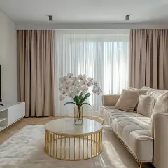 Elegancki salon z zasłonami na karniszu sufitowym z maskownicą, jasną kanapą i stolikiem kawowym.