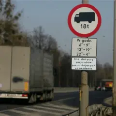 Znak zakazu ruchu dla pojazdów powyżej 18 ton w określonych godzinach.