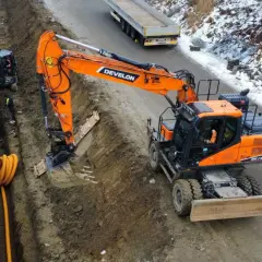 Pomarańczowe koparki Develon pracują na budowie. Poznaj maszyny budowlane nazwy i ich zastosowanie.