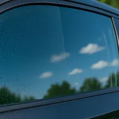 Gocce d'acqua sul vetro dell'auto, un invito a pulire vetri per un cielo terso e riflessi perfetti.