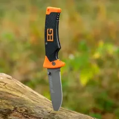 Cuchillo de supervivencia Gerber con mango naranja y negro, listo para la aventura en la naturaleza.