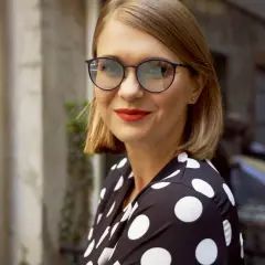 Kobieta w okularach i sukience w grochy, jak z najlepszych fotochromów.