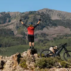 Ciclista celebra cima de montaña, listo para un camino de Santiago en bici con niños.