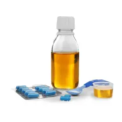 Flacone di sciroppo amoxicillina bambini, blister di capsule blu e misurino dosatore con polvere bianca.