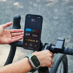 Rowerzysta monitoruje swój puls podczas treningu. Na ekranie telefonu widoczny jest puls 91 BPM, wskazujący na aktywność sportowca.