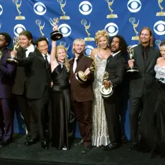 Die Besetzung von Lost feiert Emmy-Gewinne. Die Schauspieler posieren mit ihren Trophäen vor einem blauen Banner mit dem CBS-Logo.