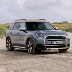 Grå Mini Cooper Countryman på sandig väg vid en strand. En del av en mini cooper countryman test.