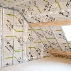 Intérieur d'un grenier en cours d'isolation, avec des panneaux pare-vapeur "Isover Vario Xtra" fixés sur des montants métalliques. La question du pare-vapeur obligatoire ou pas se pose pour cette rénovation.