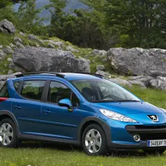 Niebieski Peugeot 207 1.4 HDI na tle skalistego krajobrazu.
