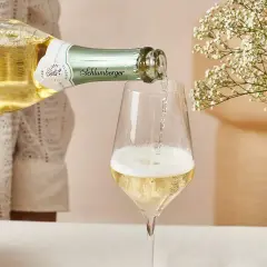 Schlumberger Grüner Veltliner Sekt wird ins Glas gegossen. Der Prosecco hat einen angenehmen prozentualen Alkoholgehalt.