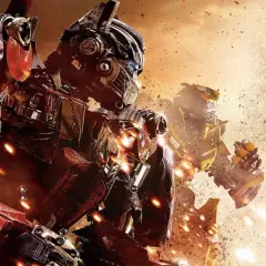Optimus Prime i Bumblebee w akcji. W tle eksplozje i pył. Widać szczegółowe transformers części.