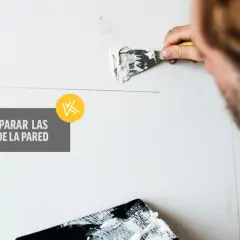 Hombre aplicando masilla para tapar grietas en la pared.