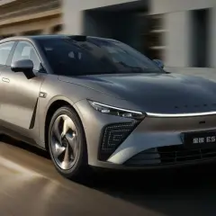 Srebrny sedan Exlantix ES pędzi ulicą, jego futurystyczny design przyciąga wzrok.