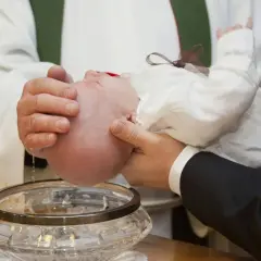 Chrzest dziecka. Czy żeby ochrzcić dziecko trzeba mieć bierzmowanie? Woda święcona spływa na główkę niemowlęcia.