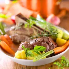 Un plat réconfortant de pot-au-feu, avec du bœuf tendre, des carottes, des pommes de terre et des poireaux, garni de persil frais.