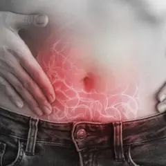 Dolore addominale, forse legato a escherichia coli in gravidanza. Mani sulla pancia con un'illustrazione degli intestini infiammati.