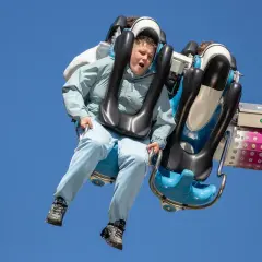Junge auf einer wilden Fahrt auf der Kirmes Ründeroth, der Wind weht durch sein Haar.