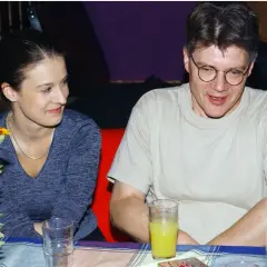 Mirosław Konarowski w prywatnym życiu, uśmiechnięty, siedzi przy stole z kobietą.