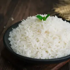 Un piatto di riso basmati, cotto alla perfezione, guarnito con una fogliolina di menta. La cottura ideale per un riso profumato.