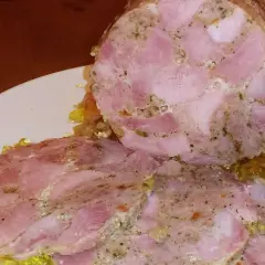 Pokrojona łopatka z szynkowara, z widocznymi kawałkami mięsa i przyprawami, podana z galaretką.