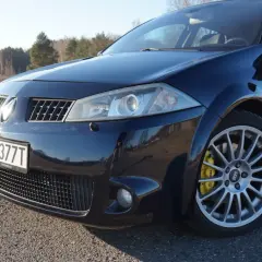 Ciemnoniebieski Renault Megane 2 z żółtymi zaciskami hamulcowymi Brembo na alufelgach.